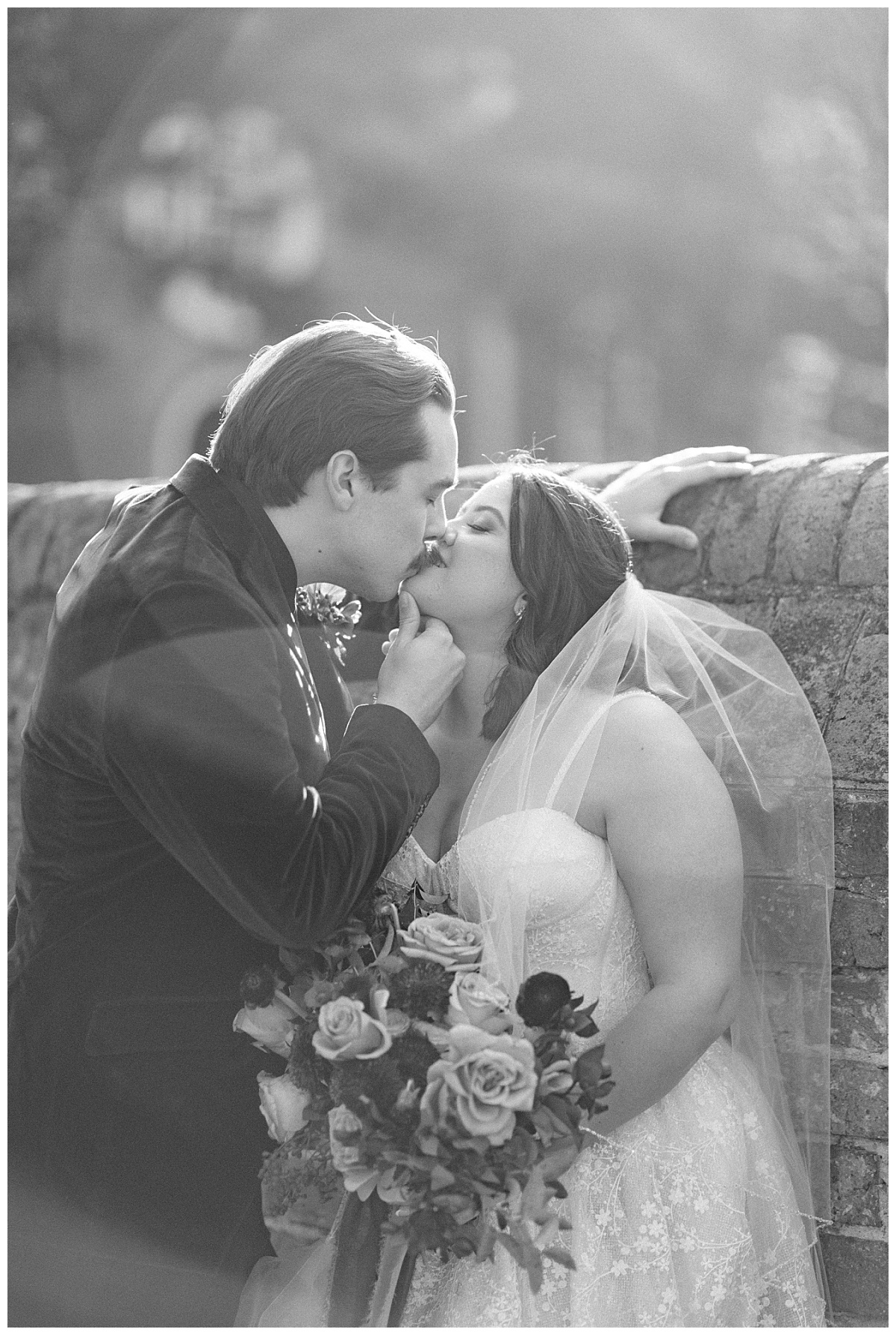 Groom kissing bride by Virginia Wedding Company