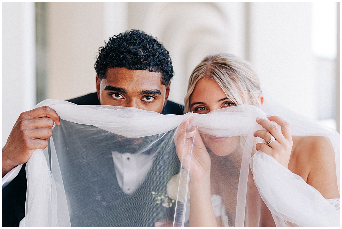bride and groom looking through veil