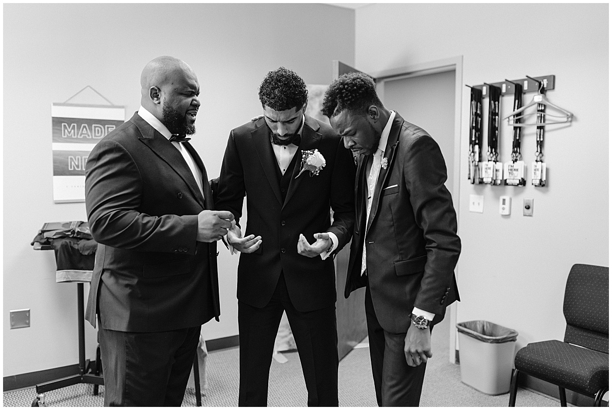 groom and groomsmen praying