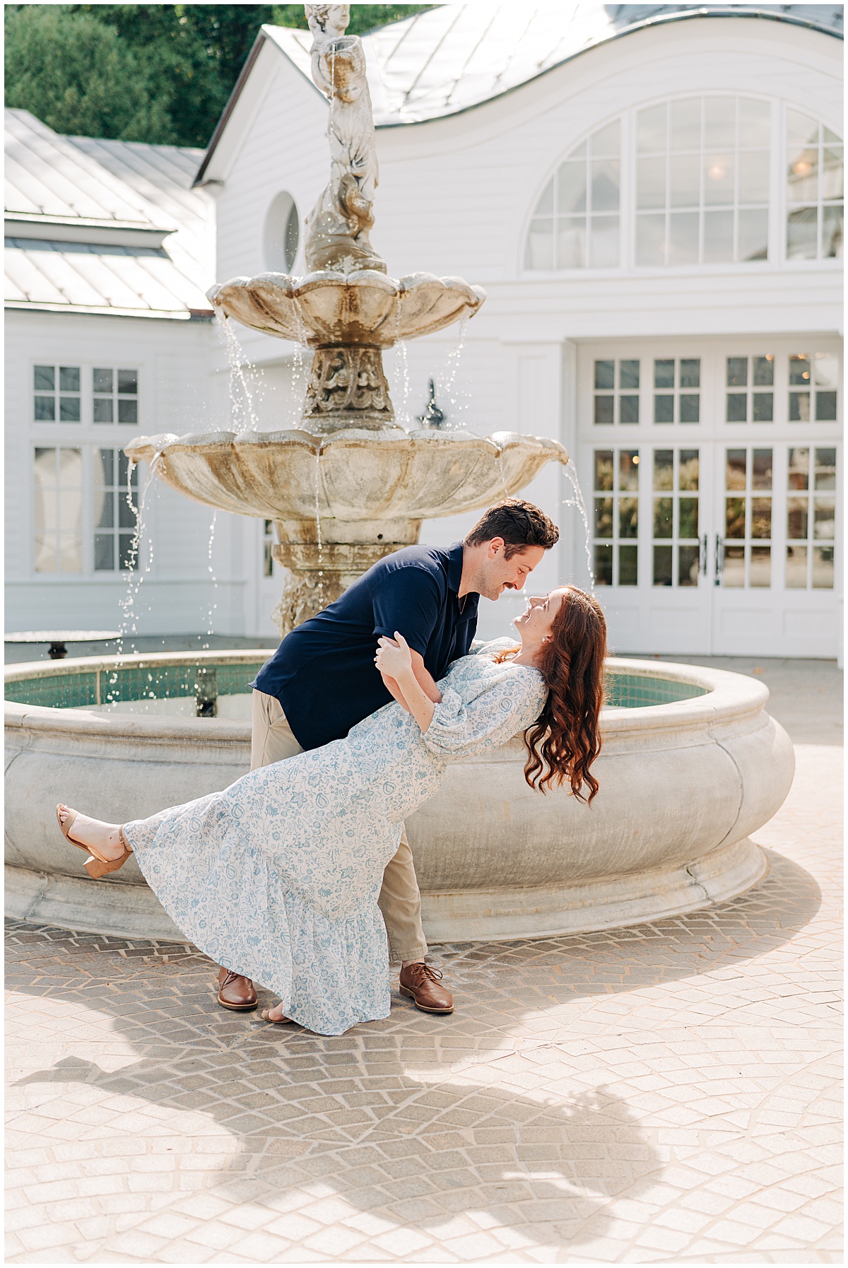 guy dipping girl by fountain